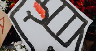 cardboard protester signs with one with fist in middle